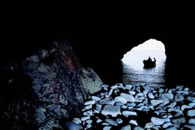 Cala Gonone - a small boat takes you to the long path that makes it possible to explore this grotto - Credit - De Agostini Picture Library